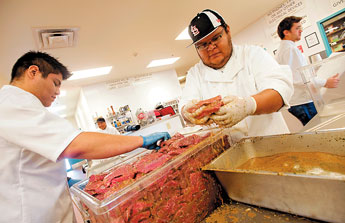 Culinary Arts students Zachary Long, left, and Ronaldo Benally marinade steaks for a banquet at the Navajo Technical College in Crownpoint on Tuesday. &copy; 2011 Gallup Independent / Adron Gardner 